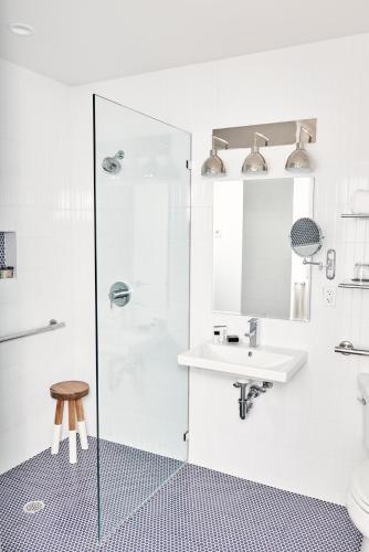 a white bathroom with a sink and a shower at The Menhaden Hotel in Greenport