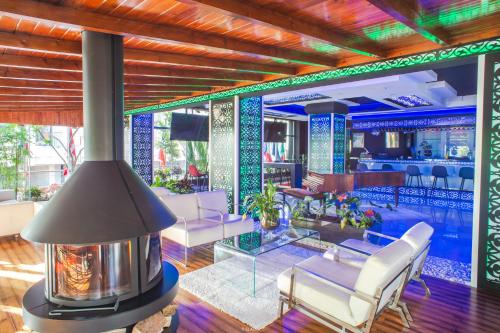 a lobby with a fireplace and chairs and a bar at Hôtel Tanjah Flandria in Tangier