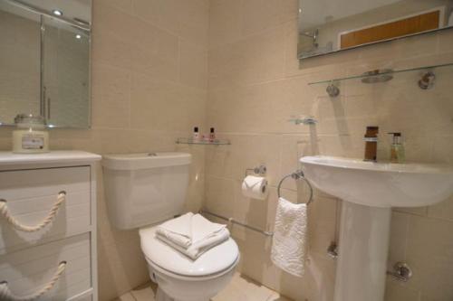 ein Badezimmer mit einem weißen WC und einem Waschbecken in der Unterkunft Foreshore at Fistral in Newquay