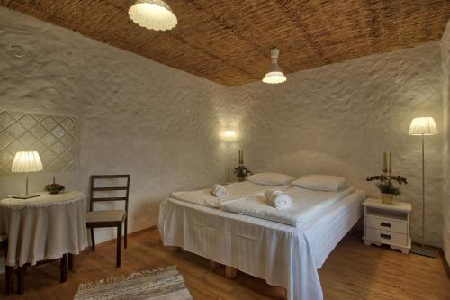 a bedroom with a bed and a table and a chair at Beguta Guest House in Haapsalu