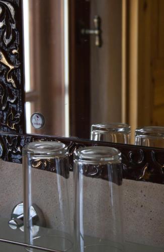 a group of glasses in front of a mirror at Beguta Guest House in Haapsalu