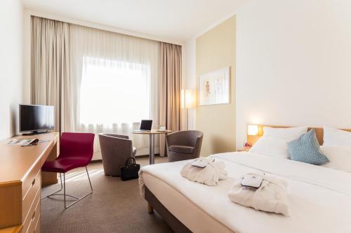 a hotel room with a large bed with towels on it at Novotel Düsseldorf City West in Düsseldorf
