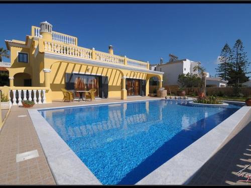 een groot zwembad voor een huis bij Villa Sesmarias Lux is a Luxury villa with private swimming poolm sea-views and AC in Carvoeiro