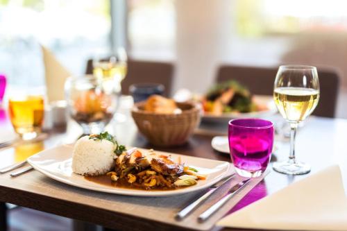 a table with a plate of food and glasses of wine at Novotel Düsseldorf City West in Düsseldorf