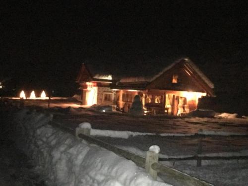 a house with lights on in the snow at night at Alpine Chalet in Santa Caterina Valfurva