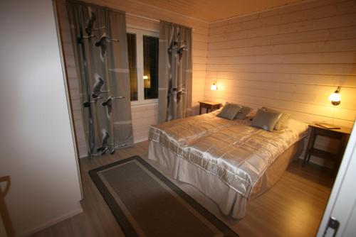 um quarto com uma cama grande num quarto em Ähtärin lomamökit - AARRE Mökki em Ahtari