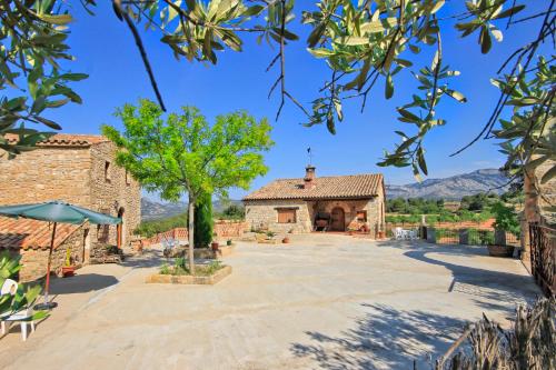 an external view of a building with a tree at Mas Del Cigarrer Allotjament Rural in Horta de San Joan