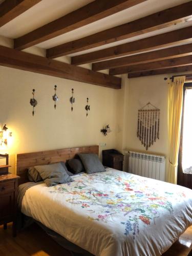 1 dormitorio con 1 cama grande con colcha de flores en Altikarra I, en Undiano