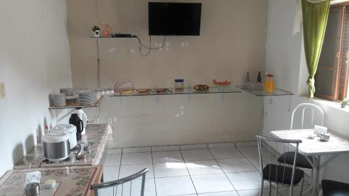 una cucina con tavolo e TV a parete di Hotel Nove De Julho a Marília