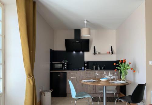 eine Küche mit einem Tisch und Stühlen im Zimmer in der Unterkunft STUDIO EN VILLE ET CAMPAGNE in Louhans