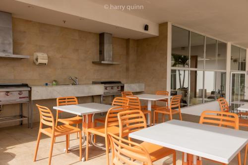 a kitchen with white tables and chairs and a counter at Apartamento El Palmar Residences in San Carlos