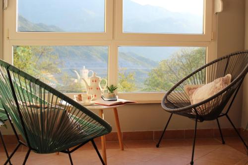 2 Stühle und ein Tisch vor einem Fenster in der Unterkunft Comfort apartment with garage Aria in Vrgorac