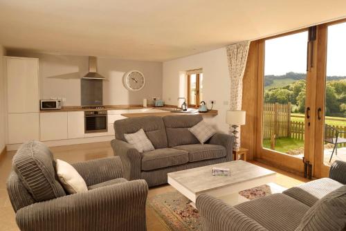 a living room with a couch and a table at Goose Run Cottage in Corscombe