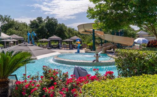 a water park with a slide and a girl in the water at Lakeway Resort & Spa in Lakeway