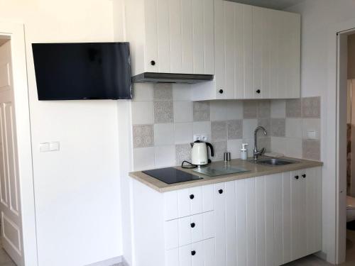 a kitchen with white cabinets and a sink at Morska Kryjówka in Niechorze