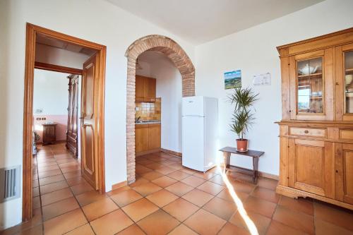 a kitchen with an archway and a white refrigerator at Agriturismo Palazzo Bandino - Wine cellar, on reservation restaurant and spa in Chianciano Terme