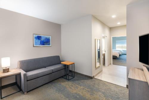 a living room with a couch and a television at Holiday Inn Lubbock South by IHG in Lubbock