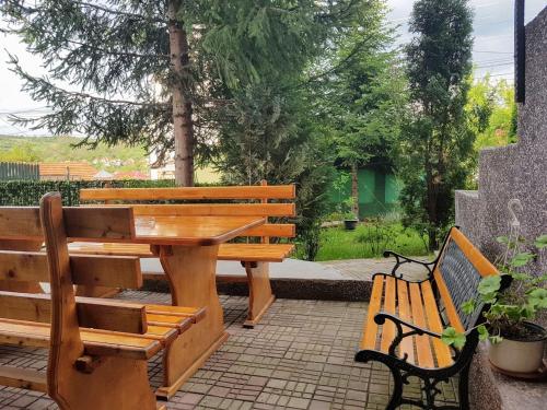 a wooden table and two benches sitting next to each other at Pensiunea Agroturistică Piscul Soarelui in Cîmpulung