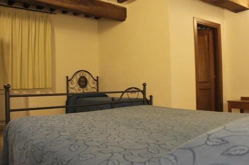 a bedroom with a bed with a blue bedspread at Grand Relais Laurenti in Gualdo Cattaneo