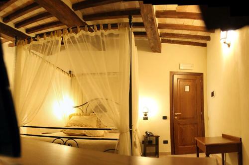 a bedroom with a bed with a mosquito net at Grand Relais Laurenti in Gualdo Cattaneo