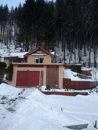 a house with a red garage in the snow at Casa Ozon in Vulcan