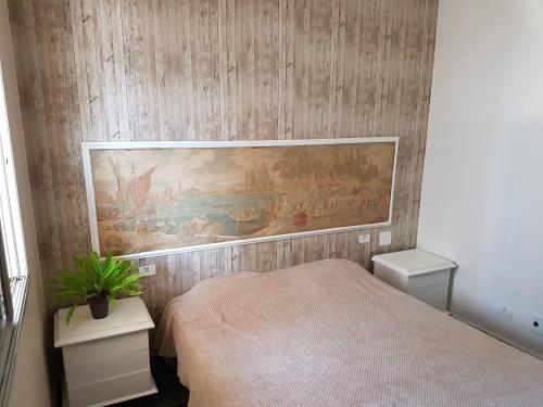 a bedroom with a bed and a painting on the wall at Apt. Enseada Guarujá in Guarujá