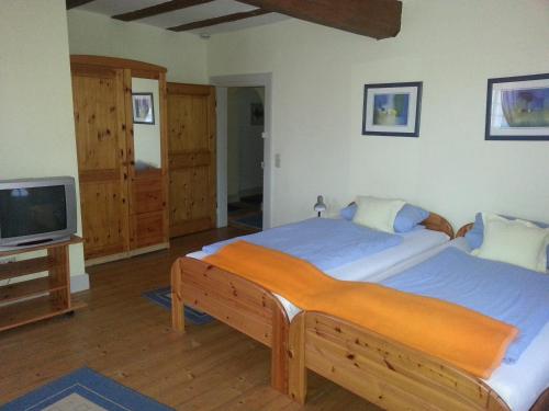 a bedroom with two beds and a flat screen tv at Hotel Blaues Haus in Otterberg