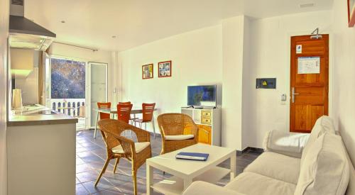 
a living room filled with furniture and a table at Apartamentos Adjovimar in Los Llanos de Aridane

