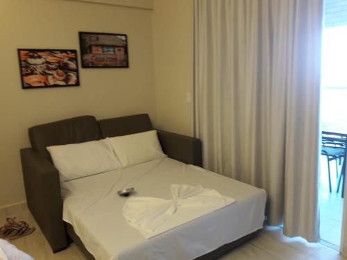 a small bedroom with a bed with a white sheets at Salinas Park Resort in Salinópolis