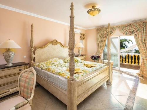 um quarto com uma cama de dossel e uma janela em Villa Vale de Lapa amazing sea views heated swimming pool jacuzzi AC - stunning house em Carvoeiro