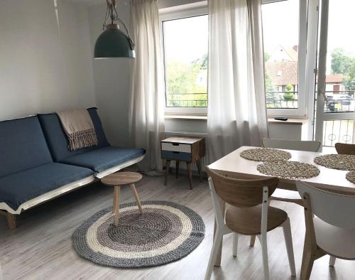 a living room with a blue couch and a table at Morska Kryjówka in Niechorze