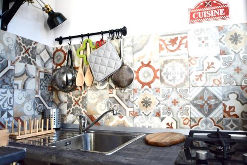 a kitchen with a sink and a tile wall at Il giardino delle zagare - miniappartamento tra Etna e mare in Riposto