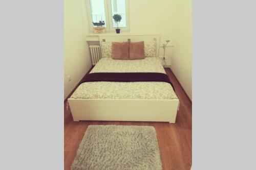 een kleine slaapkamer met een bed met twee tapijten bij Boutique Flat in Old Town in Bratislava