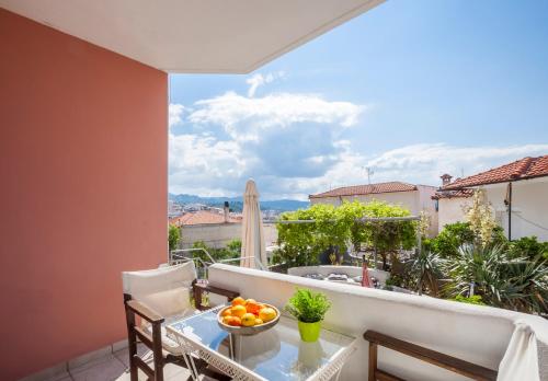 einen Balkon mit einem Tisch und einer Obstschale darauf in der Unterkunft Alterra Vita Apartments in Neos Marmaras