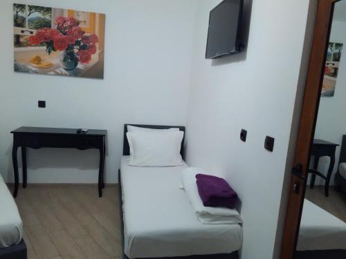 Habitación pequeña con cama y TV en la pared. en Стаи за гости Калина и Милан, en Yambol