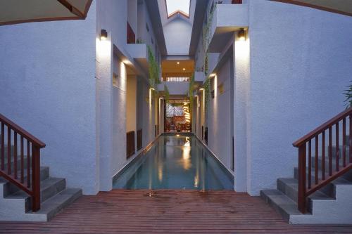 a hallway with a swimming pool in a house at Gili Kama Hotel & Villa in Gili Trawangan