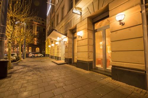 an empty street at night with lights on buildings at Top Hotel Hammer - Mainz Hauptbahnhof in Mainz