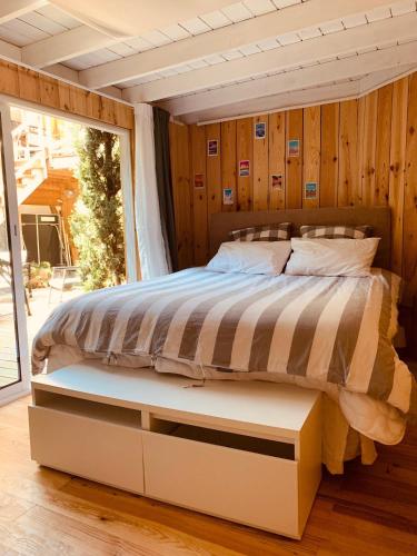 une chambre avec un lit dans une pièce avec une fenêtre dans l'établissement La Cabane du Bois, à Arcachon