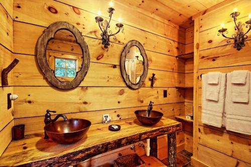 a bathroom with two copper sinks on a wooden wall at Lake Rabun Hotel in Lakemont