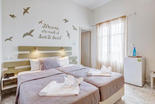 a bedroom with a large bed with towels on it at Hotel Kamelo in Vari