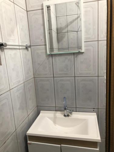 a bathroom with a white sink and a mirror at Sobrado com Piscina Perto Praia in Caraguatatuba
