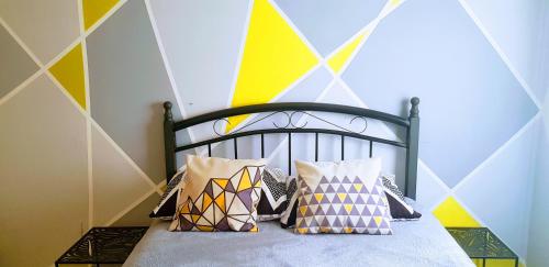 Un dormitorio con una cama con almohadas de colores. en Artichoke Boutique en Haifa