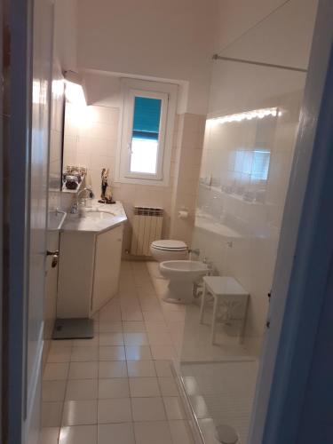 een witte badkamer met een toilet en een wastafel bij The terrace, my place in Genua