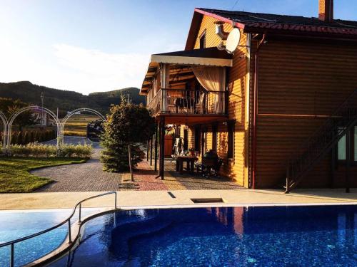 a house with a swimming pool next to a building at GorodOk in Migovo
