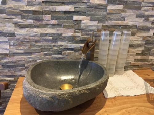 a bathroom with a stone sink with a fountain at Apart Andrea in Ischgl