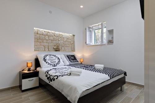 1 dormitorio con 1 cama con sábanas blancas y negras en Apartments Stella Spalato, en Split