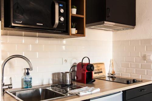 a kitchen counter with a sink and a microwave at Joli appartement à côté du Palais des Festivals in Cannes