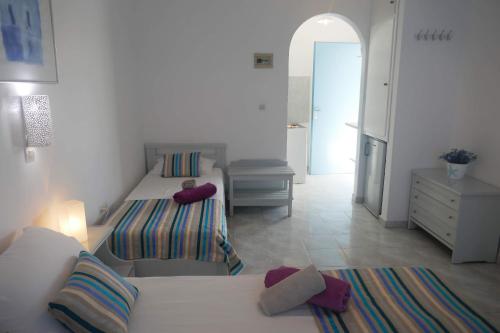 una camera con due letti e un corridoio con cassettiera di STAVROS STUDIOS a Logaras