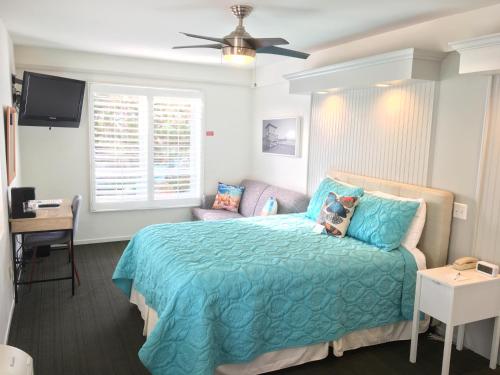 a bedroom with a bed with a blue comforter at The Sea View Inn At The Beach in Manhattan Beach