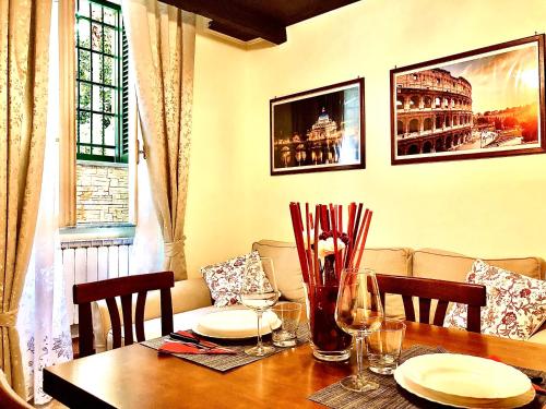 einen Esstisch mit Tellern und Weingläsern in der Unterkunft La Tana al Flaminio in Rom